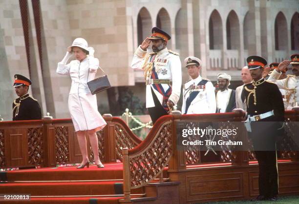 The Queen With Sultan Qaboos In Oman. During The Arrival Ceremony At Sultan Qaboos' S Home Muscat Palace. She Is Holding Onto Her Hat After It Had...