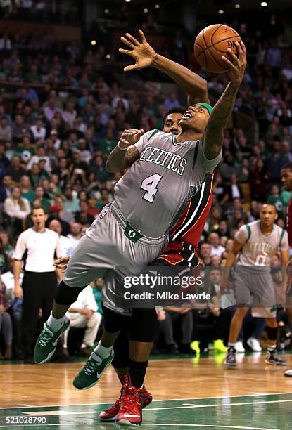 Isaiah Thomas of the Boston Celtics shoots as he falls to the ground against Hassan Whiteside of the Miami Heat in the fourth quarter at TD Garden on...