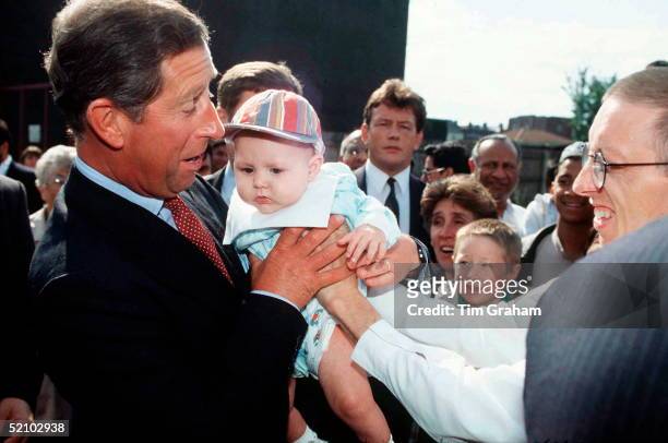 Prince Charles Meeting Locals During Visit To Housing Development In Inner City Area Of Birmingham. He Is Being Given A Baby To Hold.