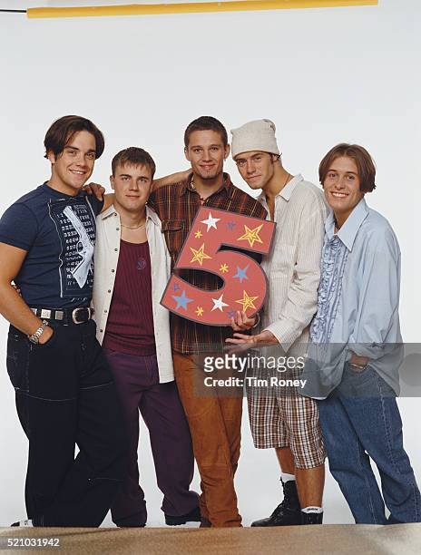 English boy band Take That holding a number 5, circa 1994. Left to right: Robbie Williams, Gary Barlow, Jason Orange, Howard Donald and Mark Owen.