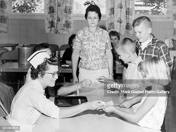 Children receiving sugar cube polio vaccine, early 1960s.