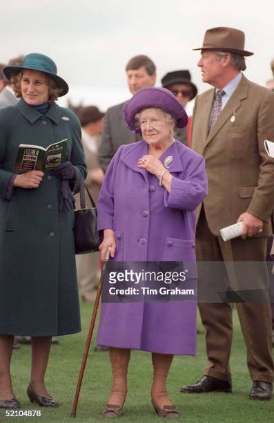 The Queen Mother Using A Walking Stick To Help Her As She Walks Around Cheltenham During The Racing. Her Lady-in-waiting, Lady Angela Oswald [ Left ]...