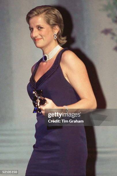 Princess Diana Carrying An Award At The Fashion Awards Ceremony In New York, USA. She Is Wearing A Blue Evening Dress And A Pearl And Sapphire...