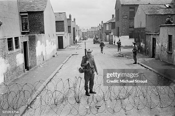 British soldiers in Belfast, Northern Ireland, July 1970. A sign on a street on the right reads 'St Patrick's Primary School'.