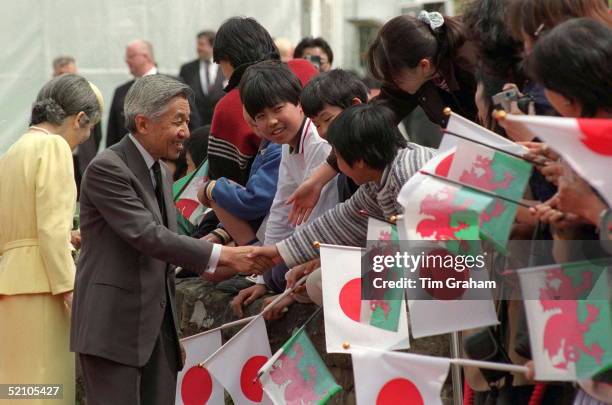 Emperor Akihito Of Japan And His Wife Empress Michiko Shaking Hands With Children Who Have Gathered To Greet Them At Cardiff Castle, Wales.
