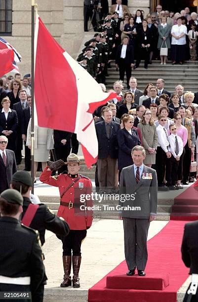 Prince Charles On A Royal Tour Of Canada Stands To Hear The National Anthem Outside The Legislative Building In Regina, Canada. A Canadian Mountie Is...