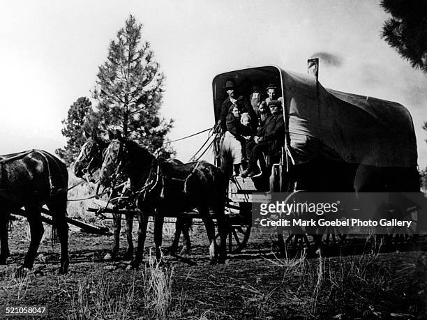 Family in heated prairie schooner, late 1890s or early 1900s.