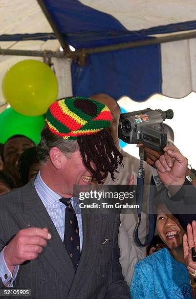 Prince Charles Models A Wool Hat Known As A Rastafarian Tam Presented To Him By Rita Marley During His Visit To Trenchtown, The Home Of Reggae Music...