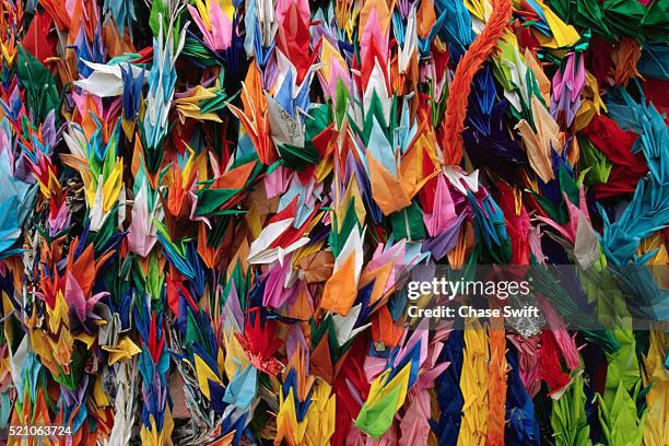 thousands of paper cranes - papierkranich stock-fotos und bilder
