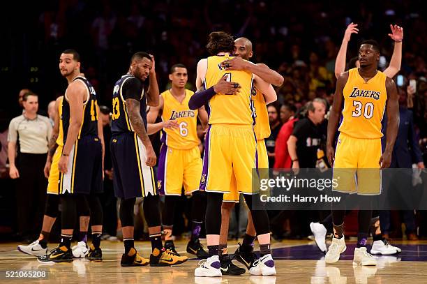 Kobe Bryant of the Los Angeles Lakers hugs teammate Ryan Kelly as Bryant is taken out of the game after scoring 60 points against the Utah Jazz at...