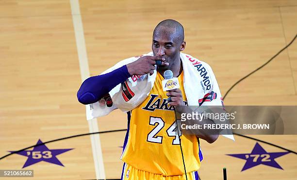 Kobe Bryant of the Los Angeles lakers gestures while addressing the fans following his final game as a Laker in their season-ending NBA western...