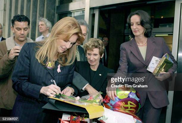 Sarah, The Duchess Of York As Patron Of The Teenage Cancer Trust Visiting University College Hospital In London Signs An Autograph. Her Sister Jane...