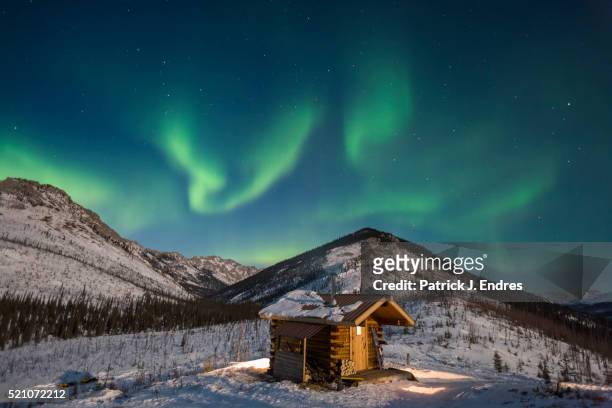 aurora over caribou bluff log cabin. - alaska stock pictures, royalty-free photos & images