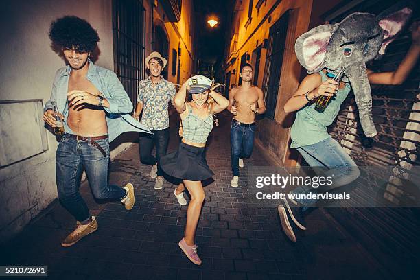 teenagers running down street during night party - costume party stock pictures, royalty-free photos & images