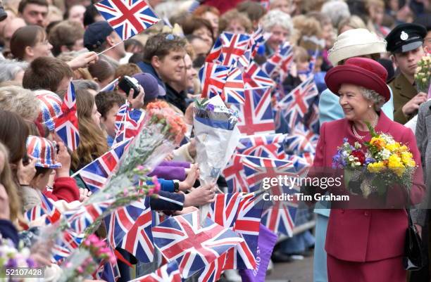 Queen Elizabeth II, Holding Flowers On Walkabout, Is Greeted By Huge Crowds Waving Union Jack Flags. The Warmth Of The Welcome She Is Receiving In...