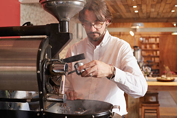 owner operating in coffee roaster - professional coffee roaster stock pictures, royalty-free photos & images