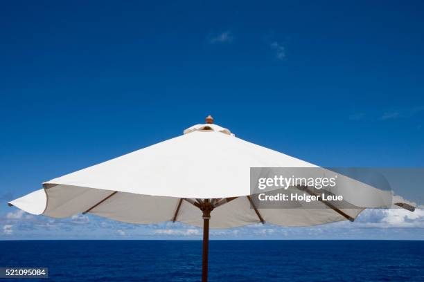 sun umbrella aboard cruise ship ms columbus of hapag-lloyd kreuzfahrten cruises in the south pacific ocean - garden umbrella stock pictures, royalty-free photos & images