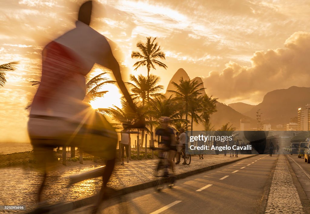Bicycle rider at sunset on Ipanema beach, Ipanema, Rio De Janeiro, Brazil