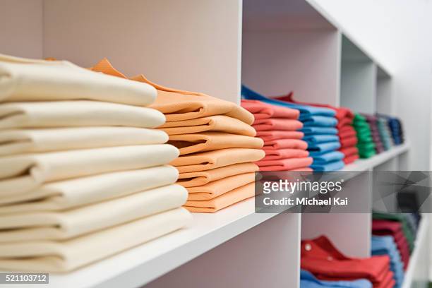 shirts on store shelves - clothing shop stock pictures, royalty-free photos & images