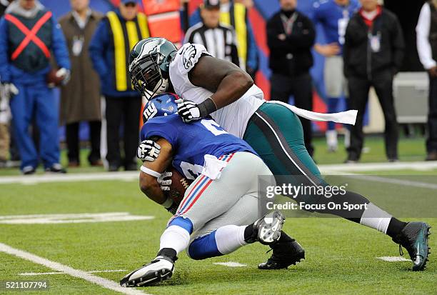 Bennie Logan of the Philadelphia Eagles tackles Rashad Jennings of the New York Giants during an NFL football game at MetLife Stadium on December 28,...