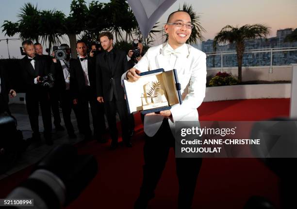 Thai director Apichatpong Weerasethakul poses after receiving the Palme dOr award for his film "Lung Boonmee Raluek Chat" during the closing ceremony...