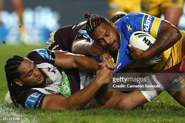 Kenneth Edwards of the Eels is tackled by Martin Taupau of the Sea Eagles during the round seven NRL match between the Manly Sea Eagles and...