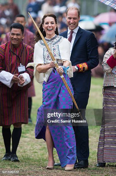 Catherine, Duchess of Cambridge and Prince William react as they take part in archery at Thimphu's open-air archery venue on April 14, 2016 in...