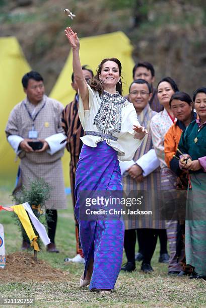 Catherine, Duchess of Cambridge throws a dart during a Bhutanese sporting demonstration on the first day of a two day visit to Bhutan on the 14th...