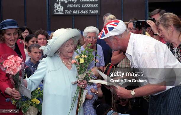 Queen Mother Visits The Citizens Advice Bureau In Mitcham, South London On The Bureau's 60th Birthday. She Hands Flowers Back To Her Lady In Waiting...