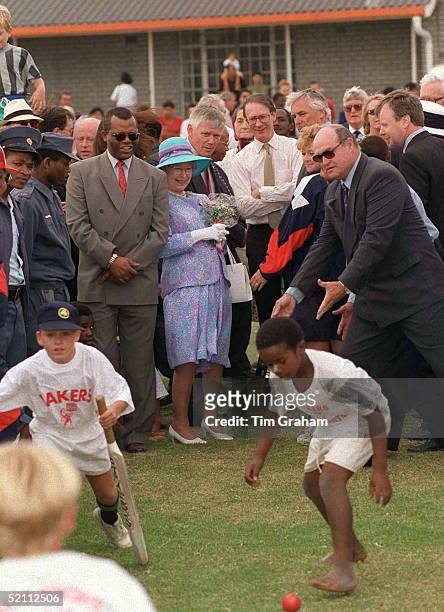 The Queen Watching Some Children Playing During Her Visit To The Langa Cricket Club Near Cape Town, South Africa. Immediately Behind Her Is Bodyguard...