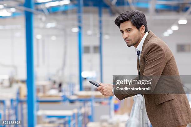 male executive on factory balcony - business audit stockfoto's en -beelden