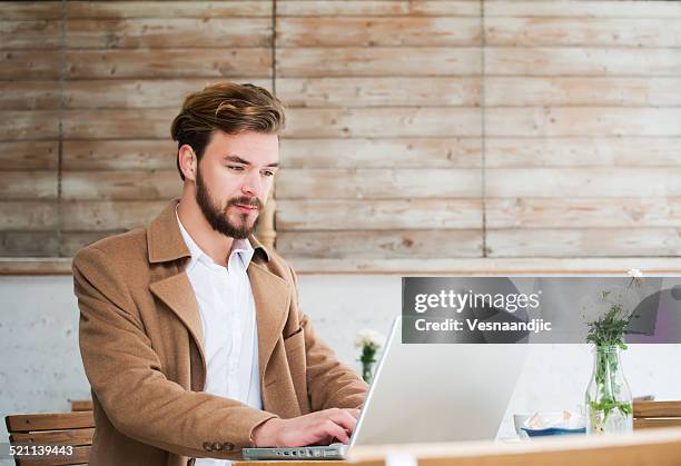 man working on laptop at cafe - duster stock pictures, royalty-free photos & images