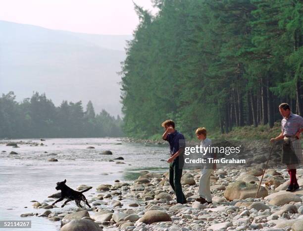 Prince Charles With Prince William & Prince Harry At Polvier By The River Dee, Balmoral Castle Estate. William Is Throwing Stones For Widgeon, His...