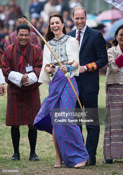 Catherine, Duchess of Cambridge and Prince William react as they take part in archery at Thimphu's open-air archery venue on April 14, 2016 in...