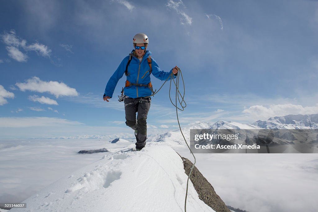 Young mountaineer follows tracks on ridge crest