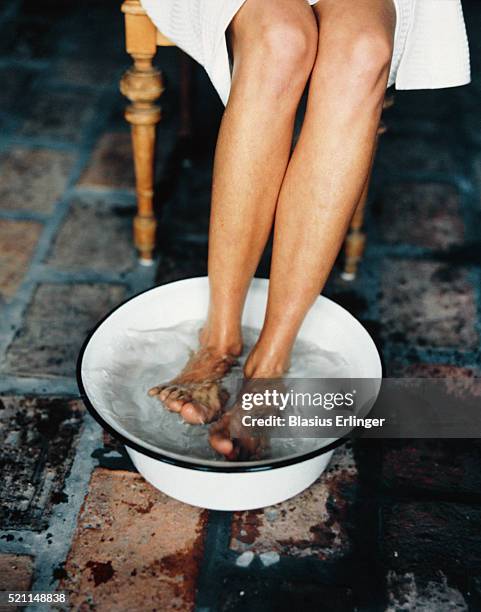 woman soaking feet in basin - wash bowl stockfoto's en -beelden