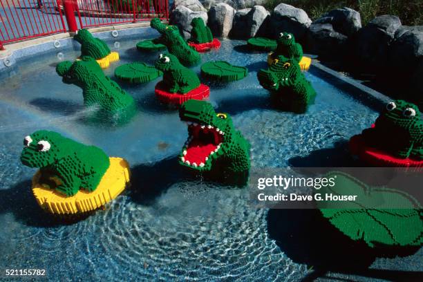 replica of frogs, lily pads and crocodiles made from legos - legoland foto e immagini stock