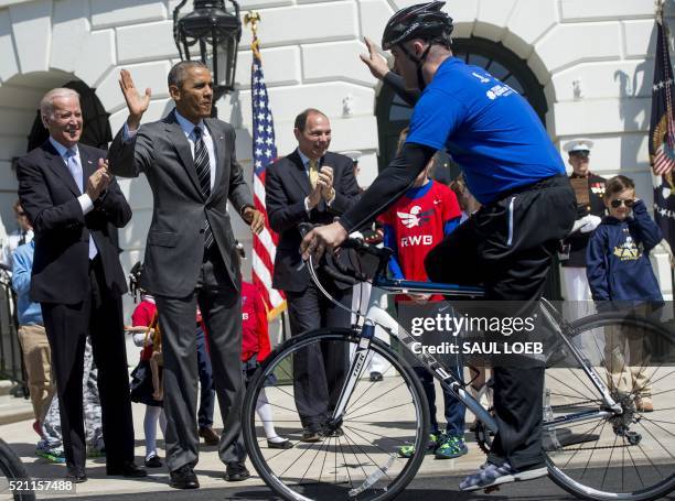 President Barack Obama gives a high-five alongside US Vice President Joe Biden , and Secretary of Veterans Affairs Robert McDonald at the start of...