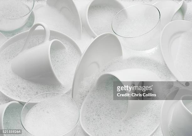 dishes in soapy water - geschirr stock-fotos und bilder