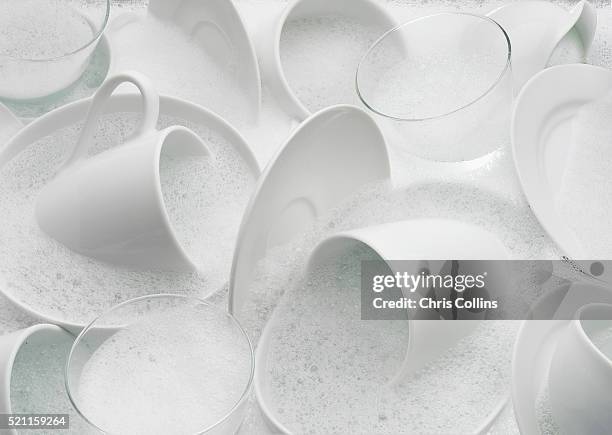 dishes in soapy water - dish foto e immagini stock