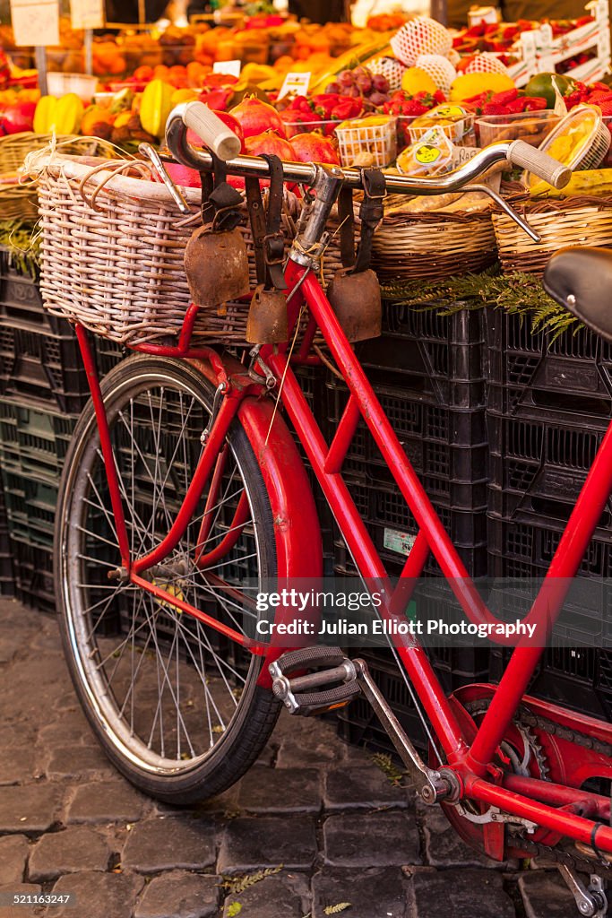A bicycle by a market stall in Rome.