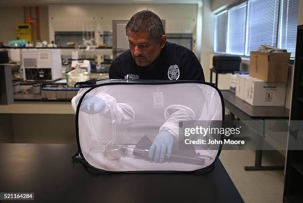 Environmental health specialist Aaron Salazar transfers mosquitos caught for testing on April 14, 2016 in McAllen, Texas. City workers are catching...