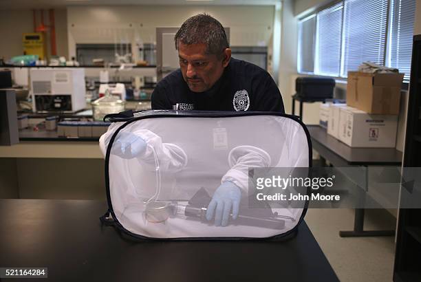 Environmental health specialist Aaron Salazar transfers mosquitos caught for testing on April 14, 2016 in McAllen, Texas. City workers are catching...