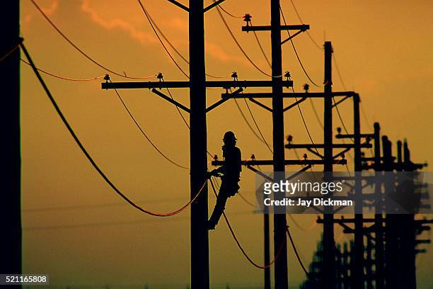lineman working on utility pole - utility pole stock pictures, royalty-free photos & images