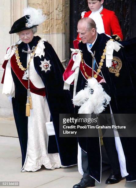 In A Black Velvet Hat With Ostrich Feather, Queen Elizabeth II, Clothed In The Heavy Traditional Robes Of The Most Noble Order Of The Garter, Leaves...