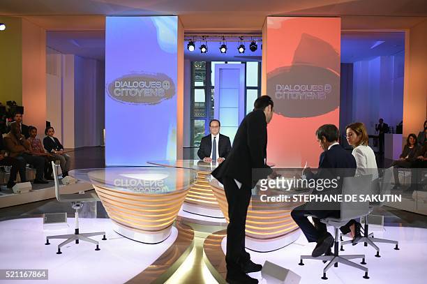 French President Francois Hollande is seen in a studio set-up by France 2, a public television station, at the Musee de L'homme as he readies to face...