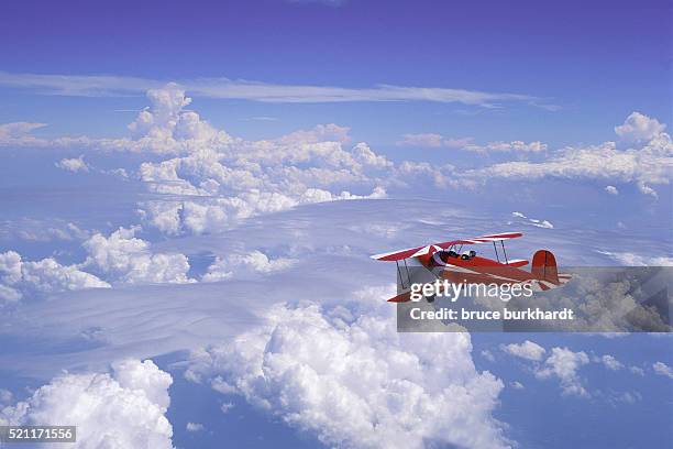 biplane flying above the clouds - biplano foto e immagini stock