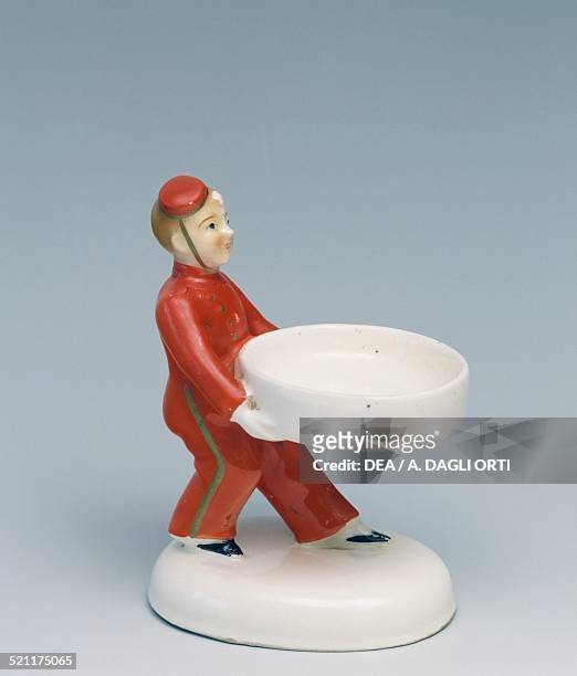 Statuette of a hotel bell boy, ceramic coin holder, Milan, 1940s. Italy, 20th century. Italy