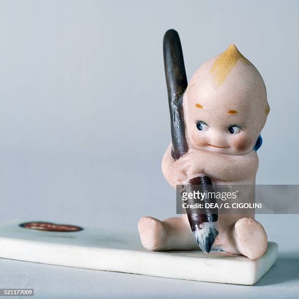 Writing Kewpie doll, celluloid doll made by Kewpie. United States of America, 20th century. United States