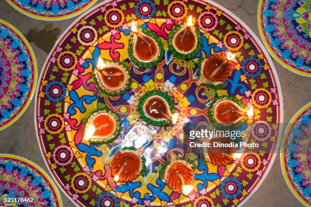 beautiful colour mat rangoli with oil lamps, diwali deepawali festival, india - rangoli stock-fotos und bilder